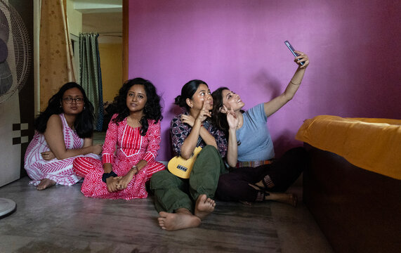 Indian young girls making fun and taking selfies inside home