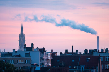 Obraz premium Colorful pink sunrise with large chimney exhaust cloud in Brussels Capital, Belgium