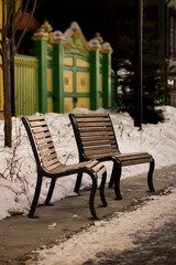 There are two lounge chairs on the city boulevard. Evening