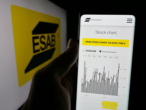 Stuttgart, Germany - 11-07-2024: Person holding cellphone with webpage of industrial company ESAB Corporation on screen in front of logo. Focus on center of phone display.