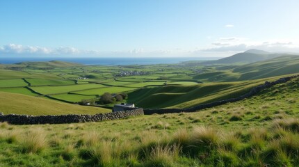 Obraz premium A breathtaking view of the Irish countryside featuring rolling green hills, stone walls, and a clear blue sky, showcasing the natural beauty of Ireland