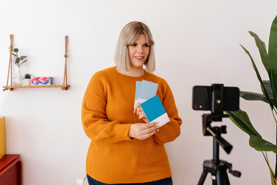 Cheerful online teacher recording video in creative workshop