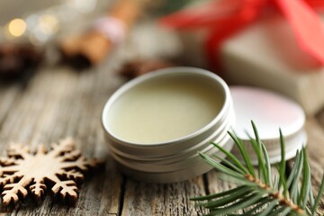 Natural solid perfume in container and Christmas decor on wooden table, closeup
