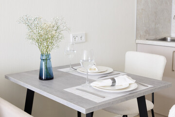 An Elegant and Modern Dining Table Setup that Features a Beautiful Floral Touch for Aesthetics