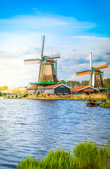 traditional Dutch windmills of Zaanse Schans over water at summer day, Netherlands