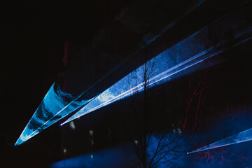 Texture laser show in the sky in the dark using a color spotlight during a concert close-up