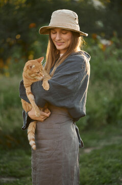 young woman with a cat with a cat in her arms in nature