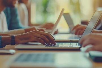 Group of people working on laptops in an office setting
