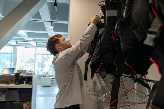 Man organizing life jackets in a nautical equipment room


