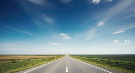 Long, empty road stretches under clear blue sky