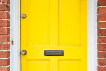 yellow door with brick wall surrounding 