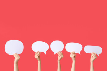 Female hands with speech bubbles on red background