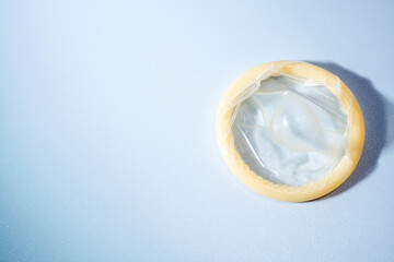 Image of a rolled-up condom on a blue background. Using a condom significantly decreases the risk of gonorrhea, chlamydia, trichomoniasis, hepatitis B, and HIV.