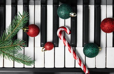 Piano keys with Christmas balls, fir tree branches and candy cane