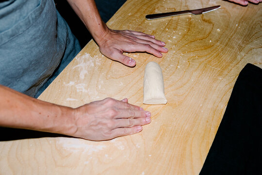 Unknown older lady learning to make Italian pasta with fresh dough