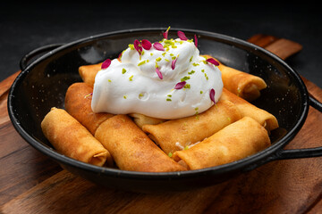Fried pancakes with cottage cheese and sour cream on a wooden board