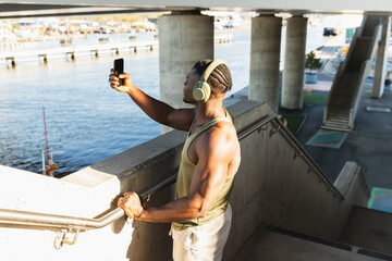 Fitness Man Standing on Stairs Taking Photo with Smartphone