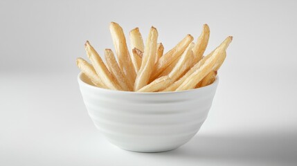 A small white bowl filled with thin, crispy french fries, perfectly arranged and lightly salted