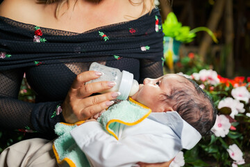 Unrecognizable woman feeding a baby