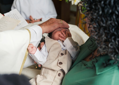 Priest touching a baby's forehead at a christening