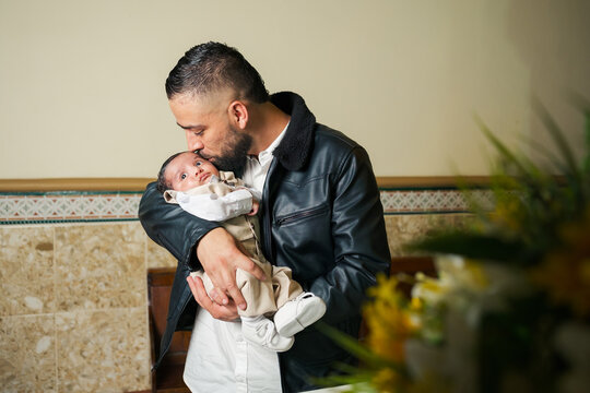 Man gives a tender kiss to a baby
