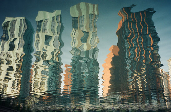 Reflections of modern skyscrapers shimmering in tranquil water