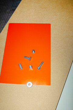Close-up of metal silver nuts, screws, nails with direct flashlight