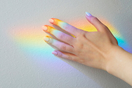 A hand with a multicolor dazzling soft rainbow reflection
