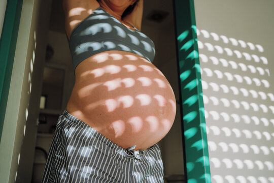 Pregnant Woman in Striped Pants with Light Shadows