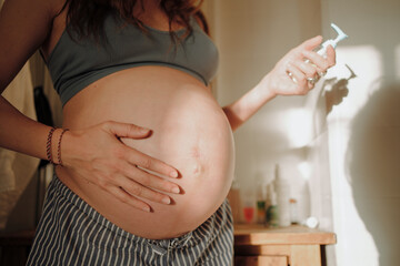 A Pregnant Woman Using Body Lotion in a Bathroom