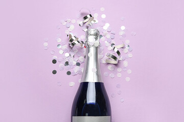 Bottle of champagne and confetti on lilac background. New Year celebration