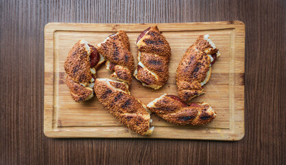 Homemade sandwiches filled with cheese and sausage, baked with a golden sesame crust.