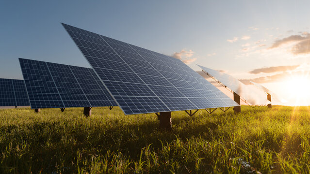 Solar panels in the sunset on a green field