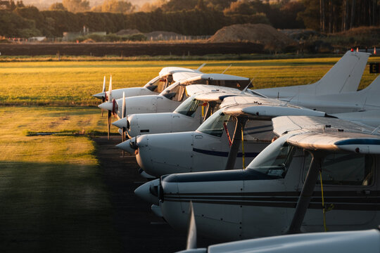 A Row Of Training Aircraft Parked On The Apron At Sunset.