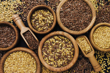 Colorful mix of various flaxseeds: golden flax and brown linseed; vegan food background