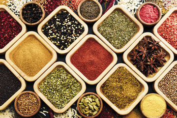 Colorful mix of herb and spice varieties: curry and coriander, turmeric and cumin, paprika and pepper, mustard and salt, cardamon and oregano and saffron. Food ingredients background