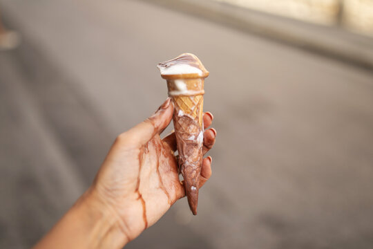 ugc of woman holding a melting ice cream in her hand