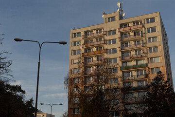 There stands a tall and impressive building that features a large satellite dish mounted on its...