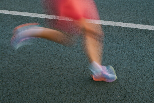 A runner blurred into motion during a city marathon 
