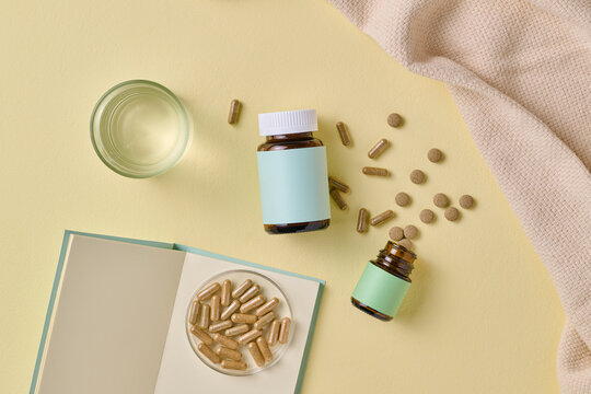 Wellness Supplements With Glass of Water and Open Notebook