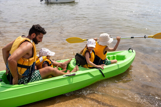 Dad and his children's going a kayak ride.