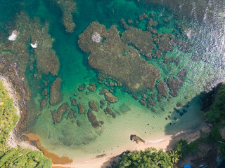 A beautiful secluded beach surrounded by reef and a blue ocean.