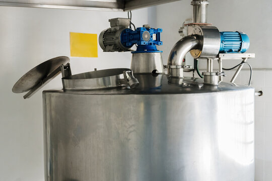 Large steel industrial mixing tank in a food processing plant