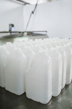 White plastic gallons on a work table