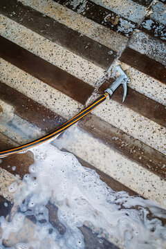 Hose on a floor with water and soap
