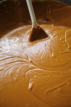 Mixing melted caramel with spatula in large bowl
