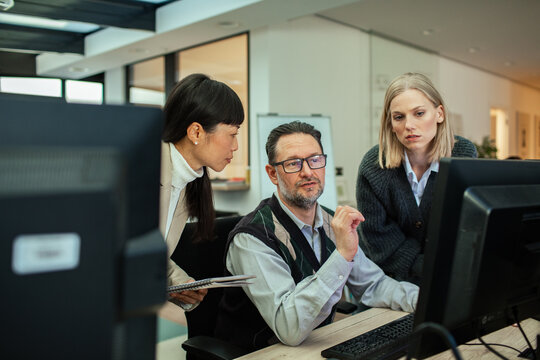 Diverse business people working together on office computer