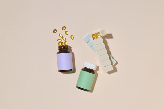 Vitamin Bottles and Pills Laid Out on a Beige Background