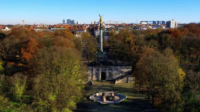 4K Aerial drone view of golden statue Nike of Paionios, angel symbol of piece, Friedensengel statue overlooking the city center Munich on a sunny warm autumn day by the river Isar