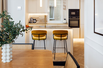 Modern kitchen with yellow stools and wooden elements